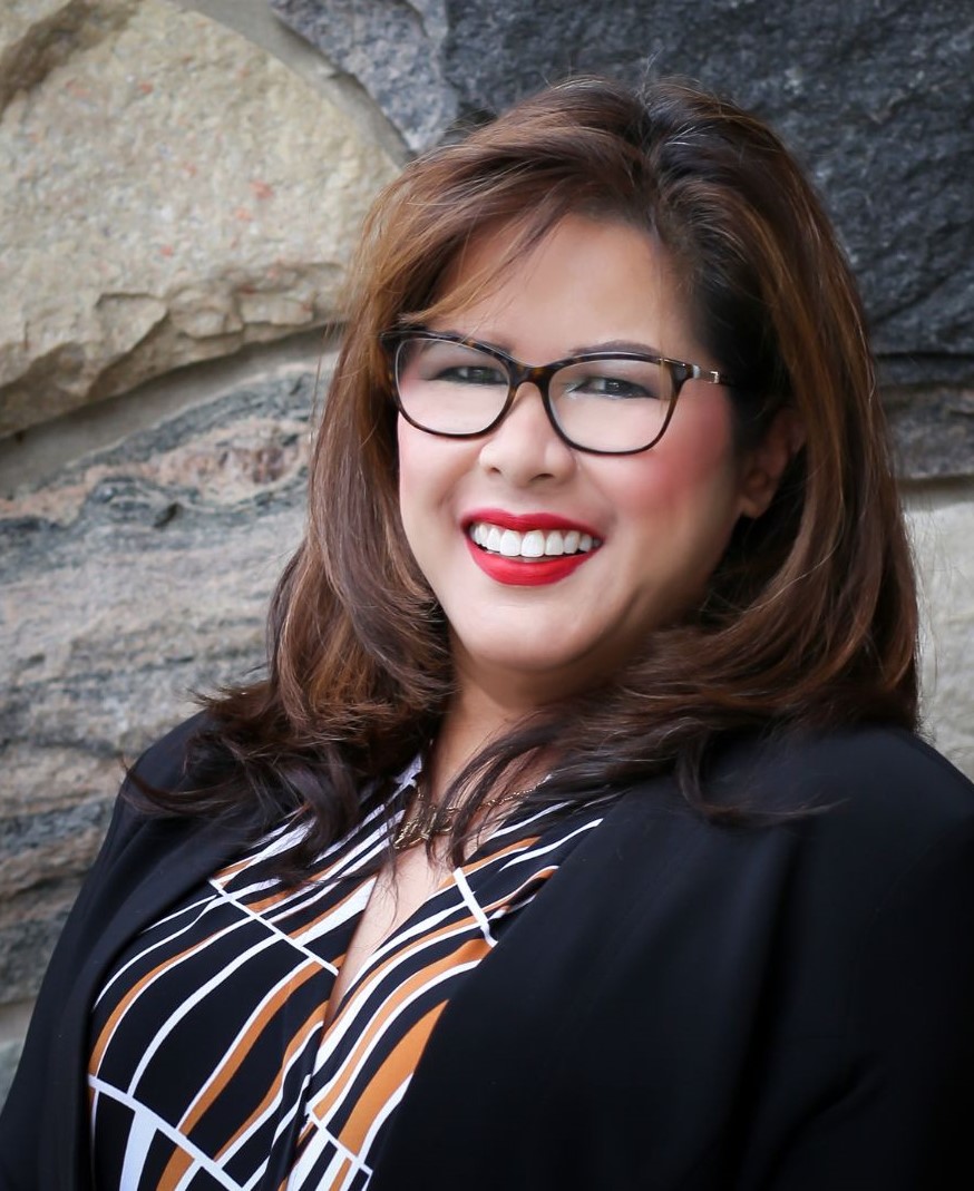 a woman wearing glasses and smiling at the camera