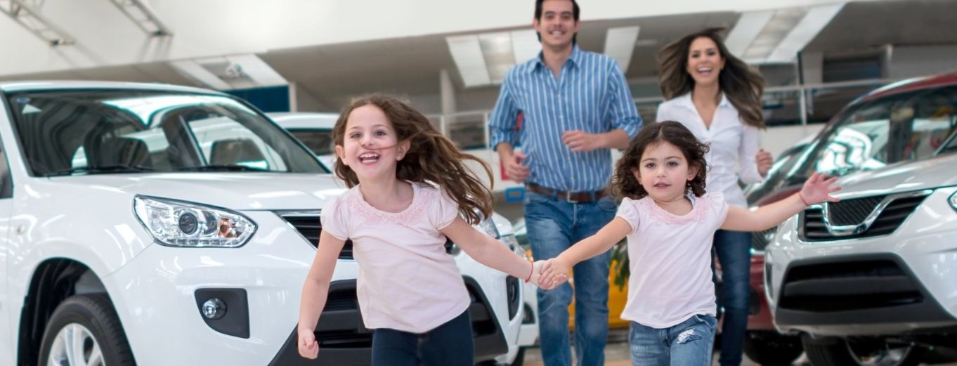 a young girl standing next to a car